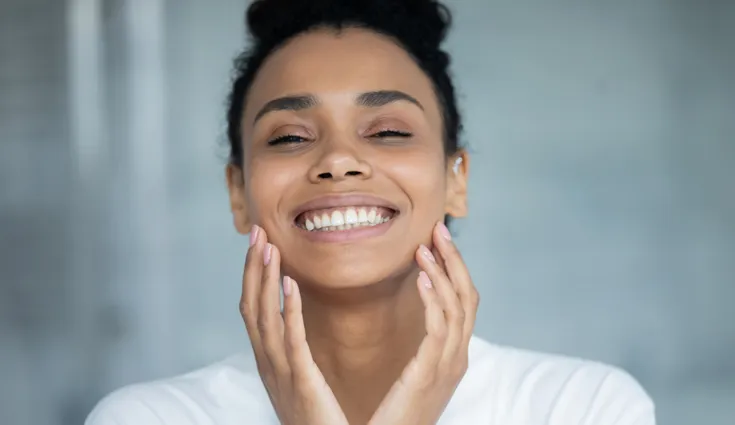 A close-up of a black woman with clear, shining skin.